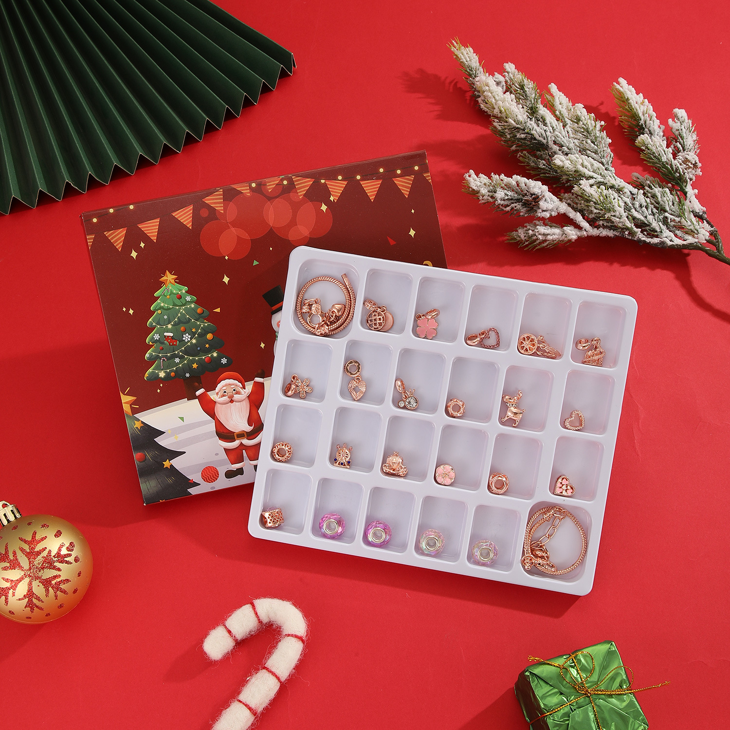Weihnachtsszene mit Schmuck in einem Tablett, Ornamenten, Weihnachtsmann und einem Weihnachtsbaum auf rotem Hintergrund.
