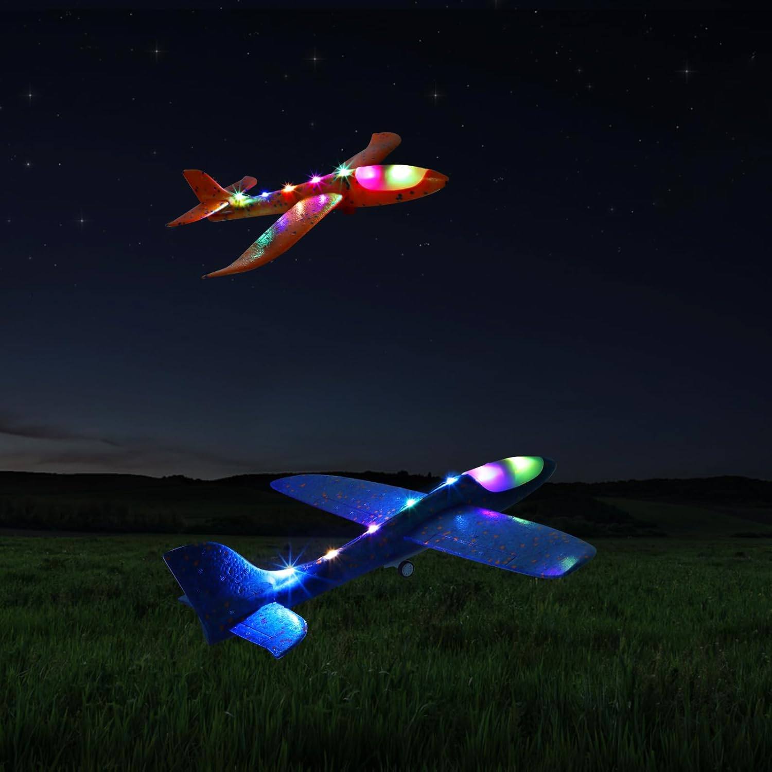 Zwei Spielzeugflugzeuge mit bunten Lichtern fliegen nachts über ein grasbewachsenes Feld unter einem Sternenhimmel.