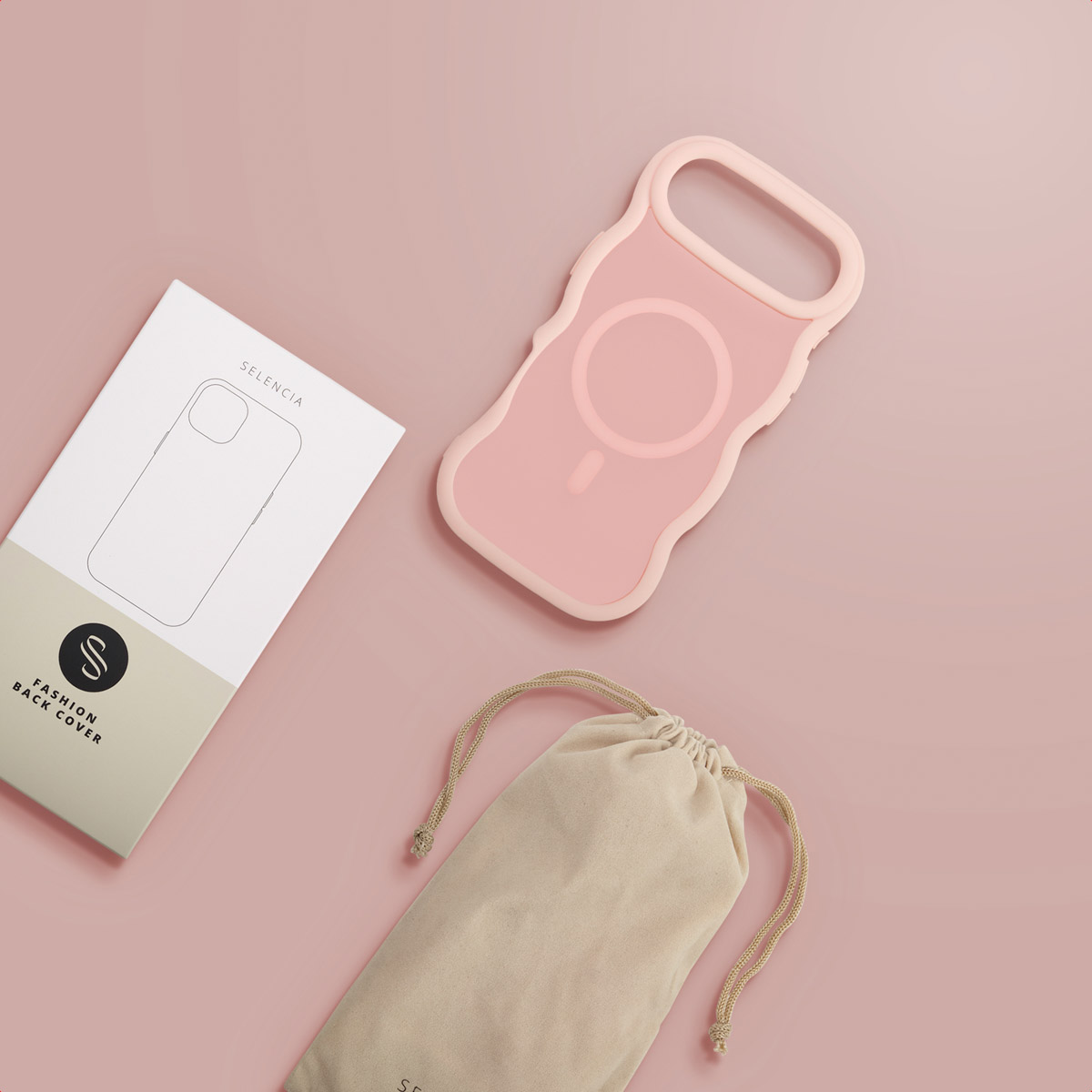 Una custodia rosa per telefono, una scatola bianca e una borsa beige con coulisse sono su una superficie rosa. La custodia ha un design unico.