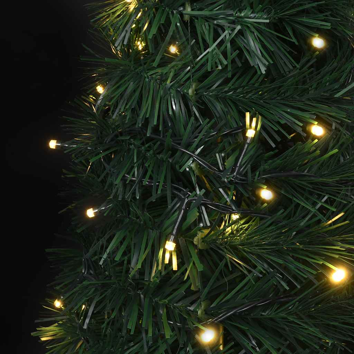 Nahaufnahme eines grünen Weihnachtsbaums mit kleinen, warmweißen LED-Leuchten. Die Lichter sind auf schwarzen Drähten aufgereiht.