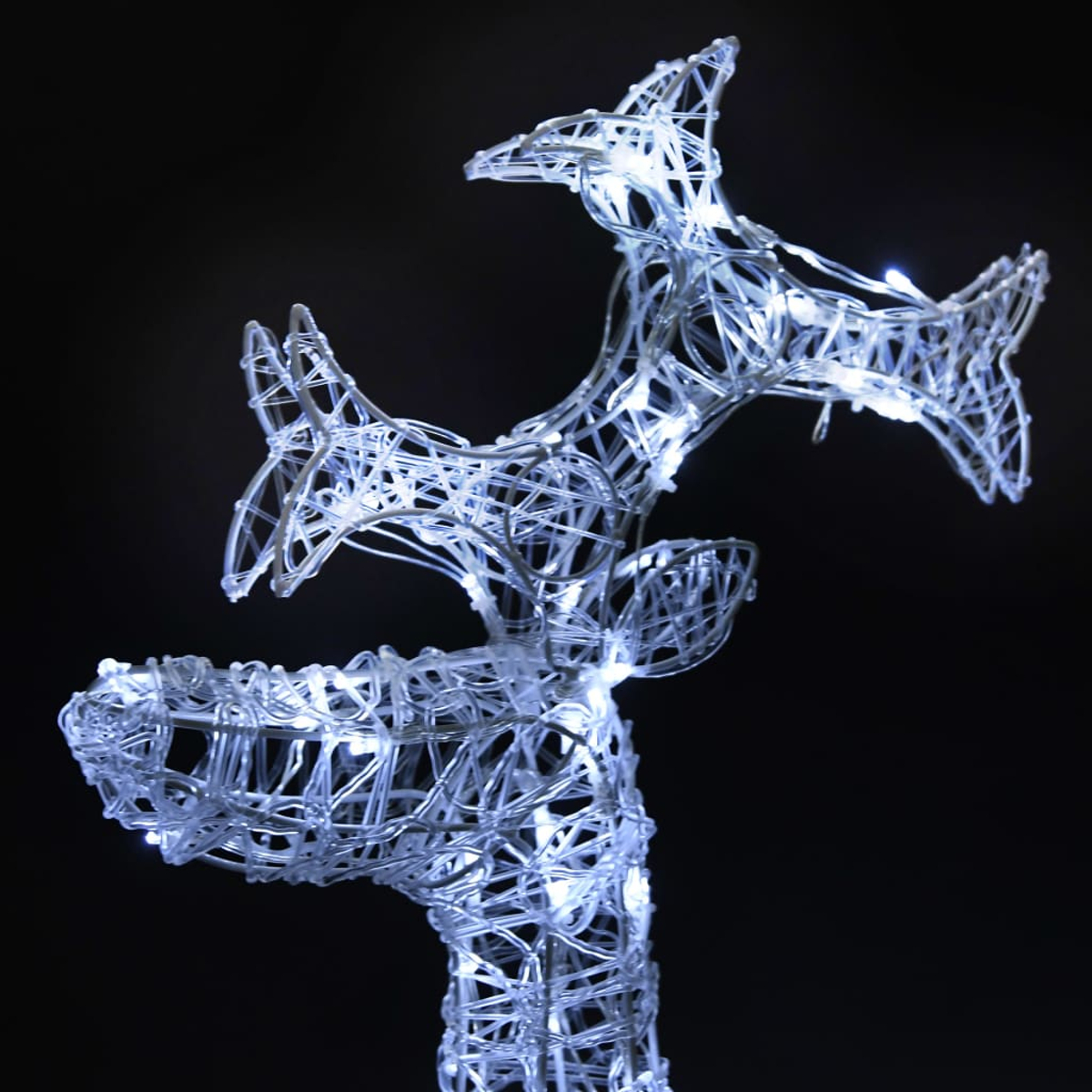 Drahtgerüst-Rentierskulptur, beleuchtet mit weißen Lichtern vor schwarzem Hintergrund. Die Skulptur ist detailliert und künstlerisch.