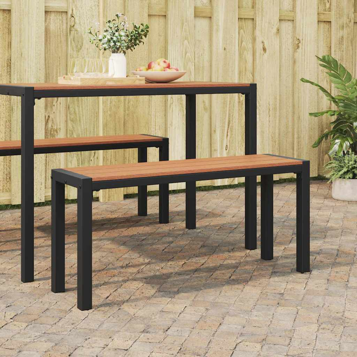 Terrassenset: Tisch, Bank und kleinere Bank. Holzplatten mit schwarzen Metallrahmen. Äpfel und Pflanzen sind sichtbar.