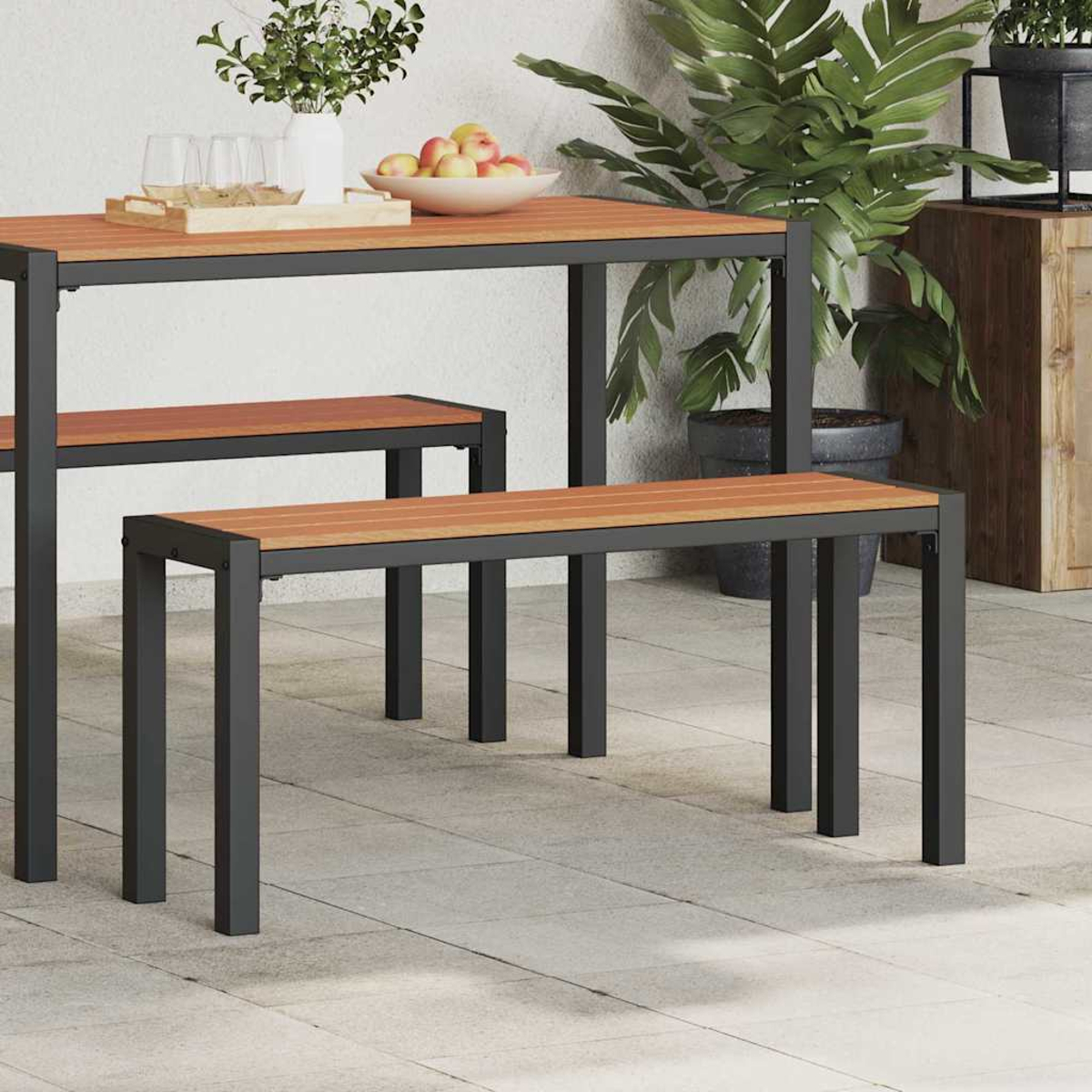 Gartenset: Holztisch und Bänke mit schwarzen Metallrahmen. Obst und Pflanzen stehen auf dem Tisch. Grauer Fliesenboden.
