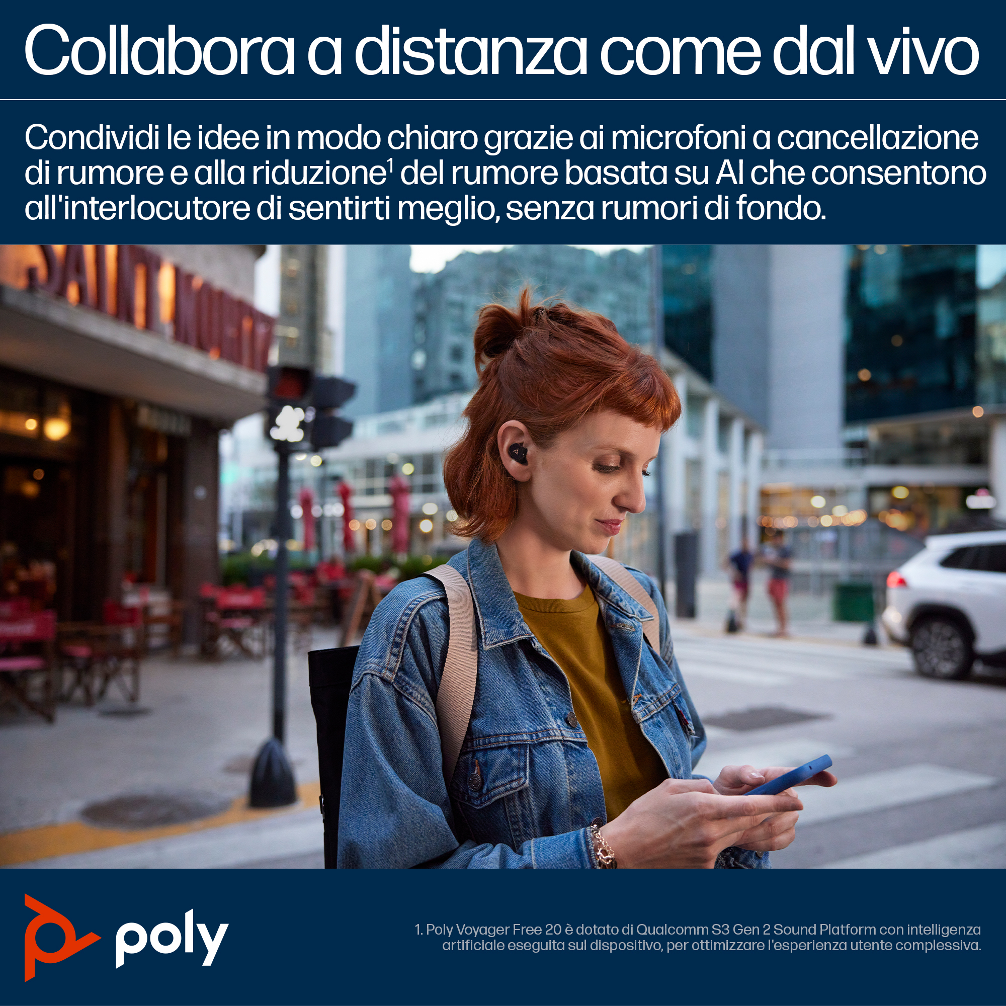 Donna con capelli rossi, auricolari e giacca di jeans, tiene un telefono, in un ambiente urbano.