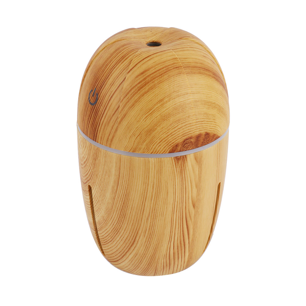 Ein holztexturierter, ovaler Luftbefeuchter mit Ein-/Aus-Taste, Silberband und kleinen Belüftungsöffnungen. Die Oberseite hat ein Loch.