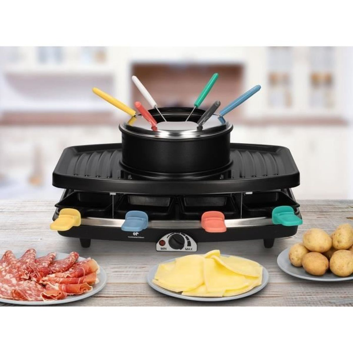 Ein Fondue-Set mit einem schwarzen Topf und farbigen Gabeln. Teller mit Fleisch, Käse und Kartoffeln sind darum angeordnet.