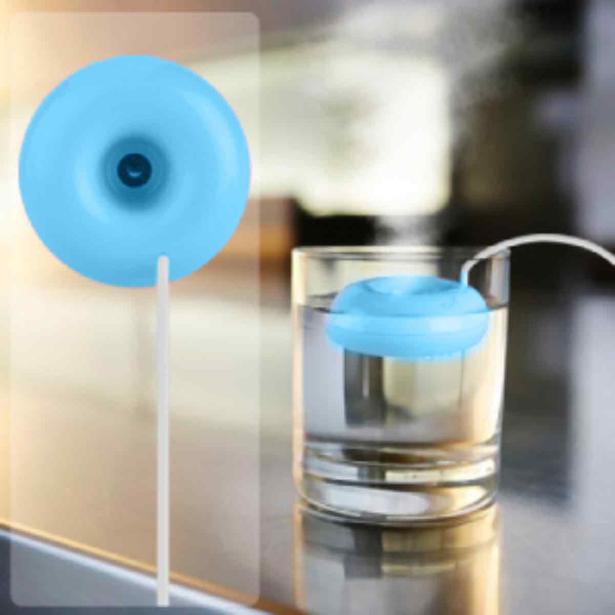 Ein blaues, donut-förmiges Gerät und ein ähnliches Gerät, das in einem Glas Wasser schwimmt. Ein weißes Kabel verbindet sie. Weißer Hintergrund.