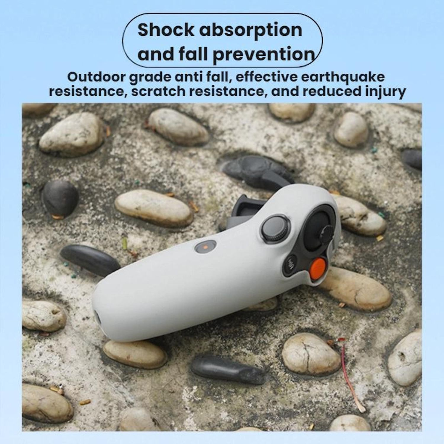 Un controller bianco è appoggiato su una superficie di pietra. Il controller ha pulsanti e un accento arancione. Lo sfondo presenta pietre.