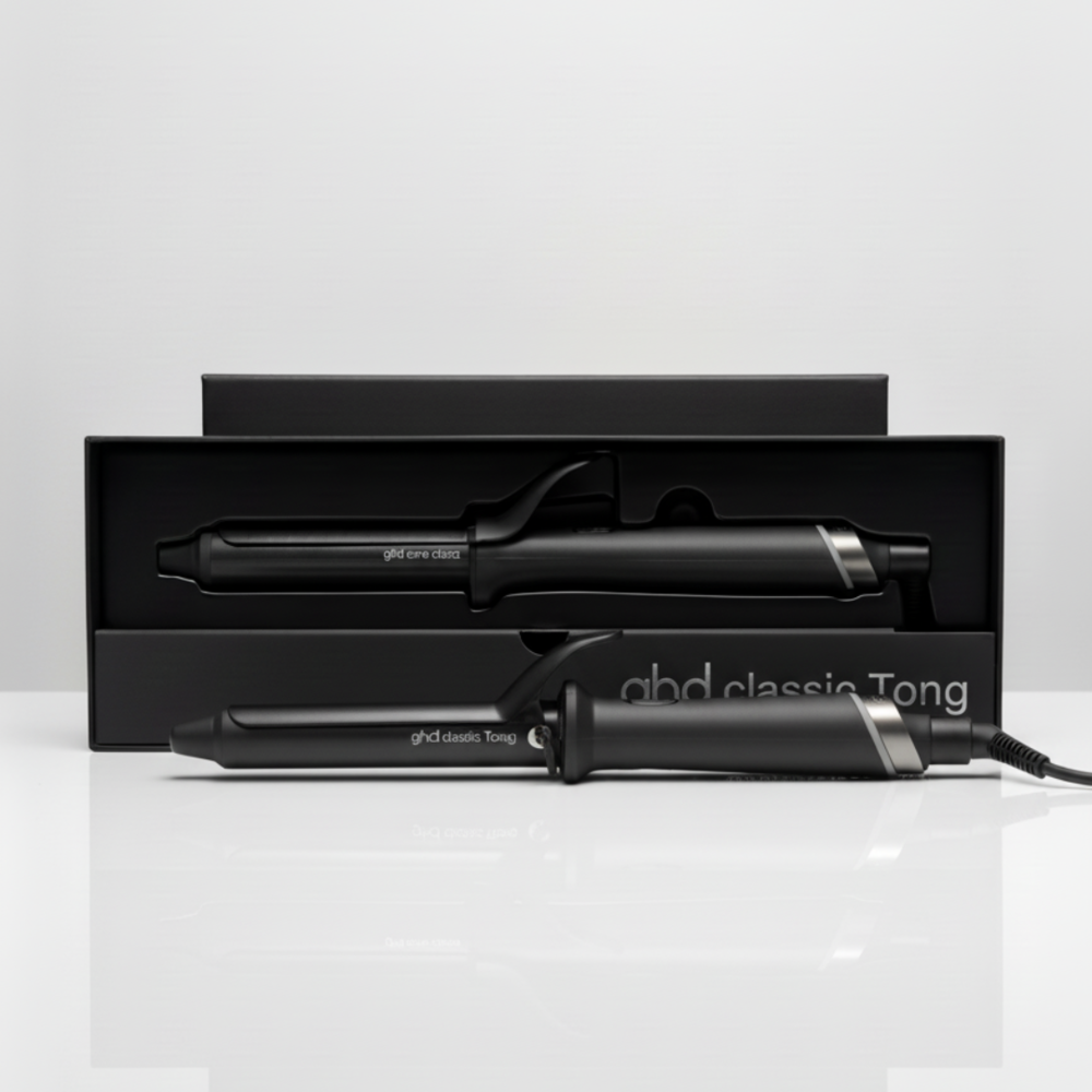 Set di arricciacapelli ghd classic Tong nero in una scatola nera. Un ferro è fuori, l'altro è dentro la scatola. Sfondo bianco.
