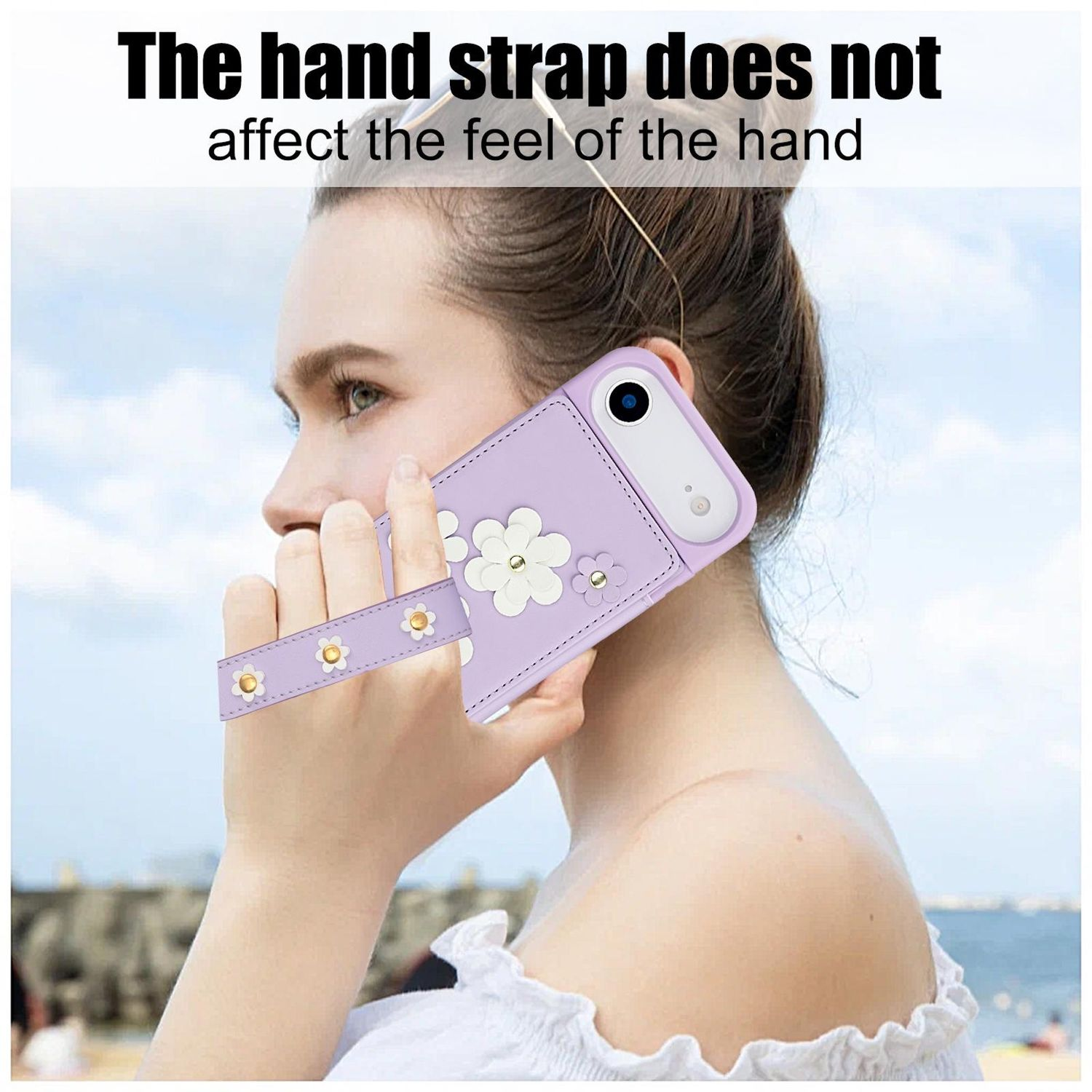Una mujer sostiene una funda morada para teléfono con detalles de flores blancas. La funda tiene una correa para la mano. El texto dice: 'La correa no afecta la sensación'.
