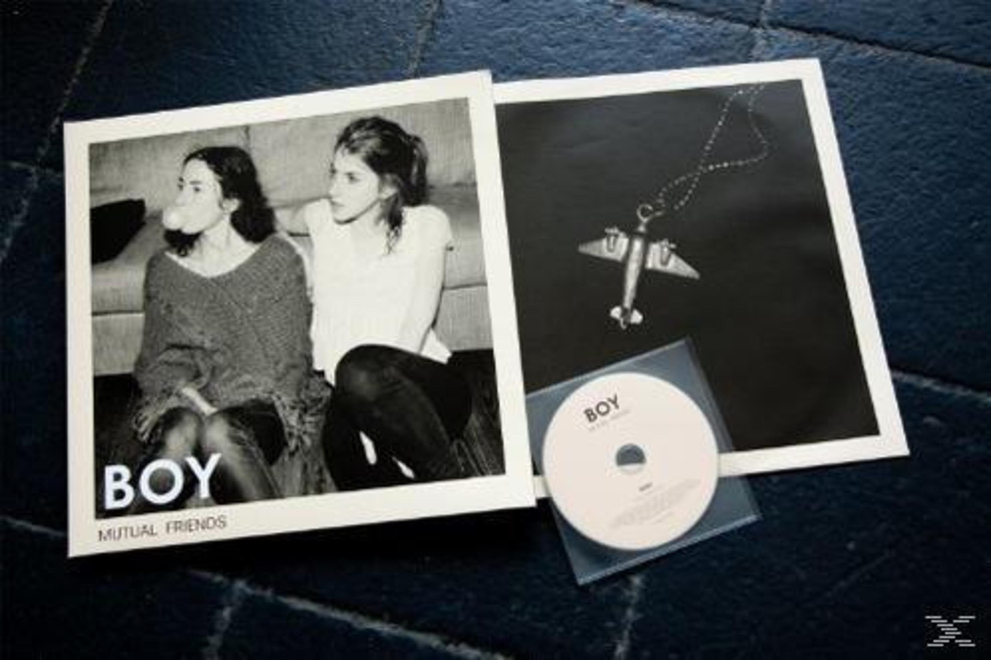 Albumcover mit zwei Frauen, eine mit Kaugummi. Enthält CD und Flugzeug-Halskette auf schwarzem Hintergrund.