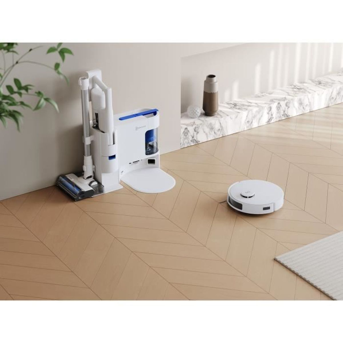 Un aspirateur robot blanc et une station de charge se trouvent sur un plancher en bois. Un vase et un petit tapis sont également présents.