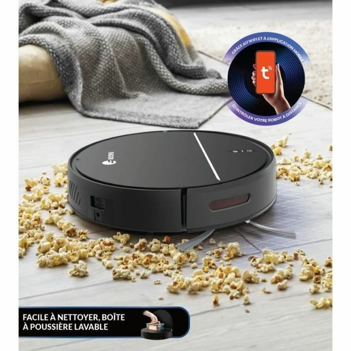 Ein schwarzer Roboter-Staubsauger auf einem Holzboden, bedeckt mit Popcorn. Ein Smartphone zeigt App-Steuerung. Eine Decke und ein Kissen im Hintergrund.