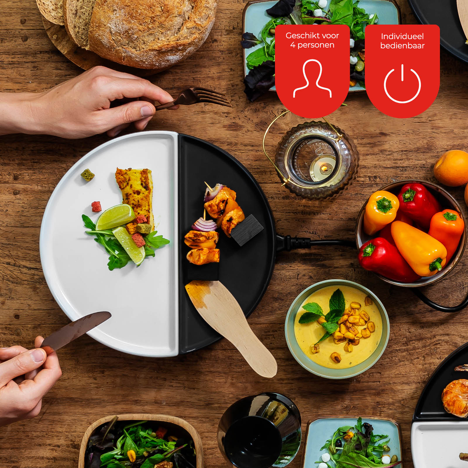 A table with food: bread, salad, soup, peppers, and a divided plate with food. Hands are using utensils.