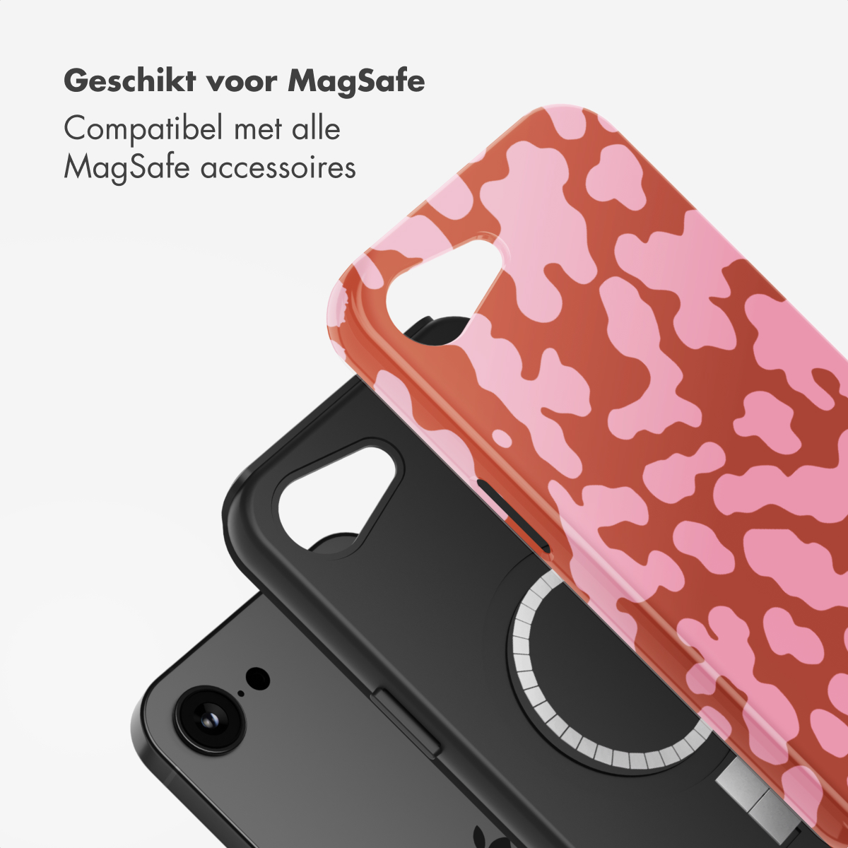 Een telefoon met een roze koeienprint hoesje. De hoes zit over een zwarte telefoonhoes en een zwarte telefoon.