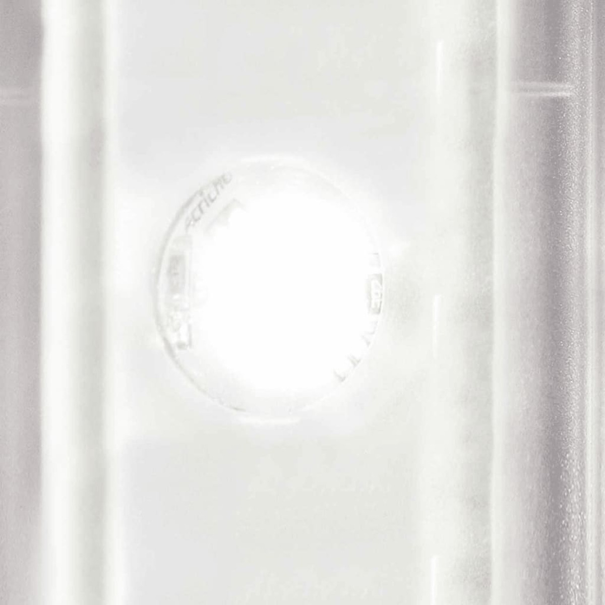 Ein helles weißes Licht scheint durch ein transparentes kreisförmiges Objekt mit Text. Der Hintergrund ist weiß mit vertikalen Linien.