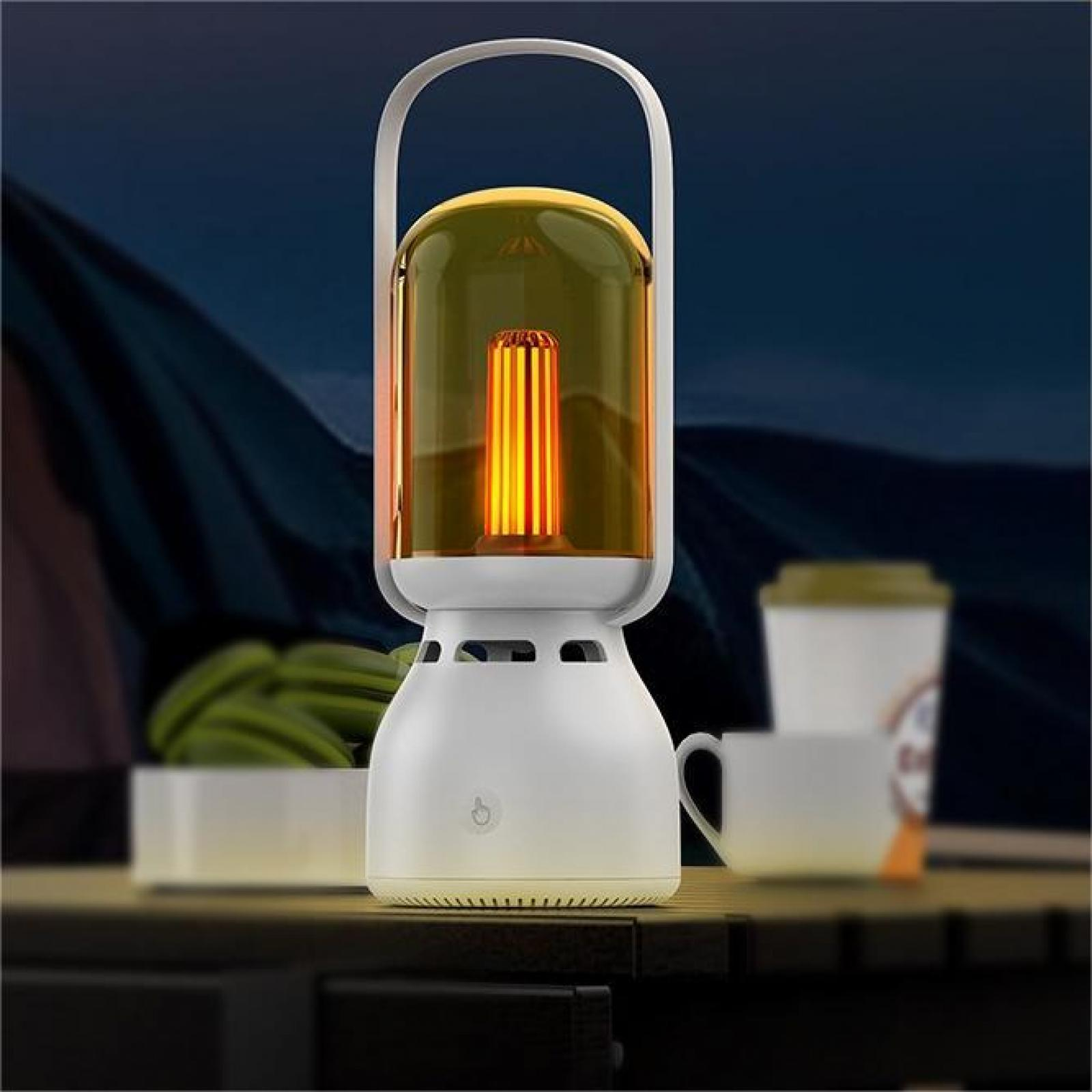 Eine weiße Lampe mit Griff, ein leuchtendes orangefarbenes Licht in einem klaren Glas, eine Tasse und eine Schüssel mit grünen Objekten sind sichtbar.