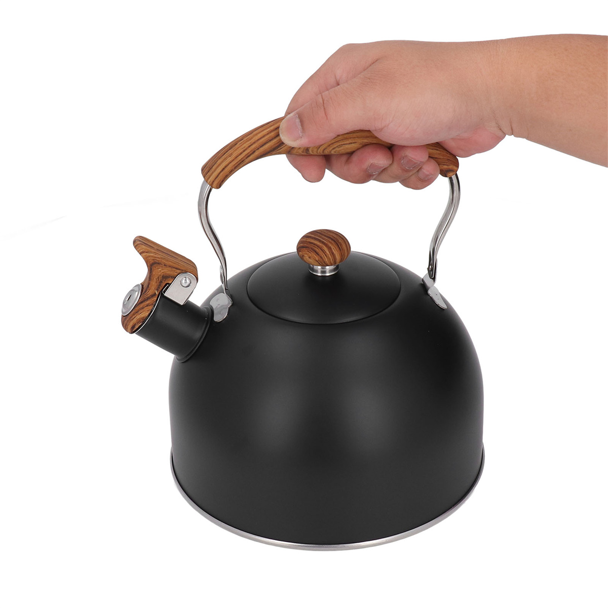 Ein schwarzer Wasserkocher mit Holzgriff und Deckel wird von einer Hand gehalten. Der Wasserkocher steht auf weißem Hintergrund.
