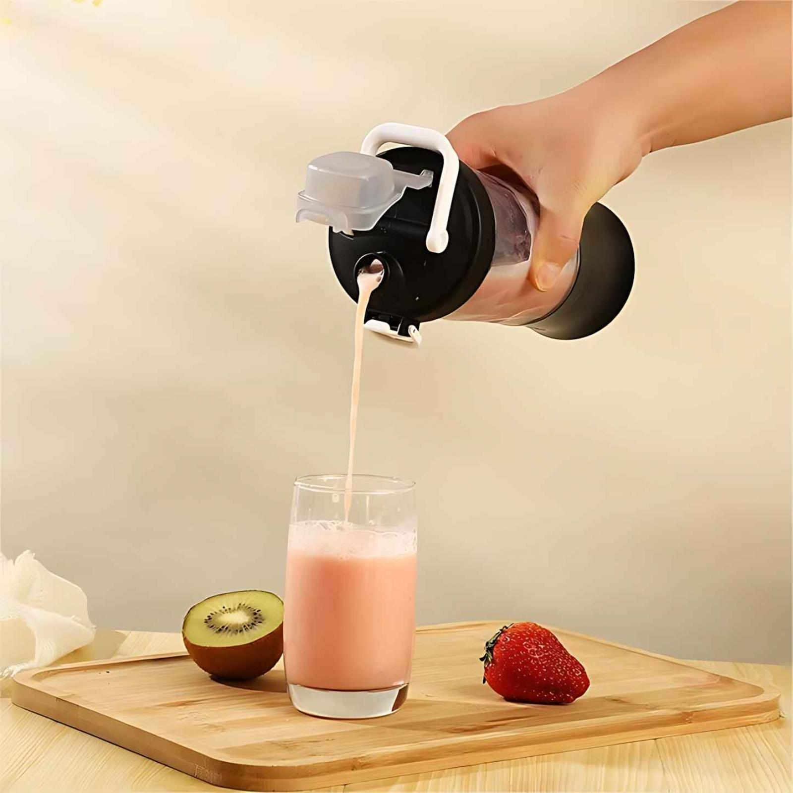Eine Hand gießt einen rosa Smoothie aus einem Mixer in ein Glas. Kiwi und Erdbeere liegen auf einem Holztablett.