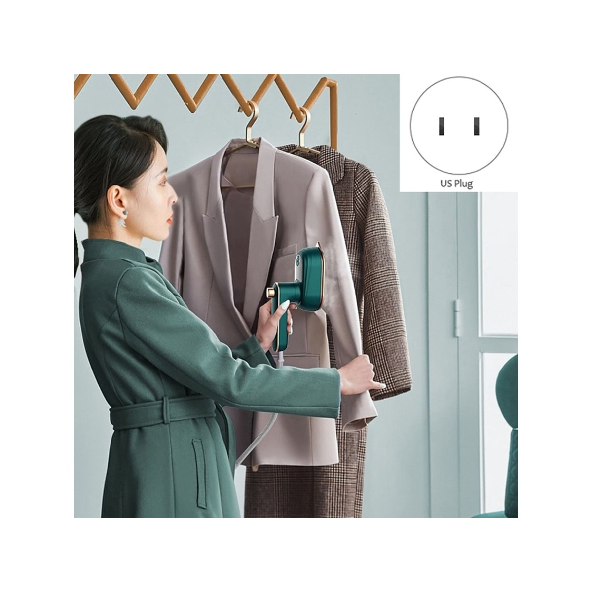Eine Frau dämpft einen Blazer. Ein grüner Steamer wird auf einem grauen Blazer verwendet. Eine andere Jacke hängt daneben. US-Stecker in der Ecke.