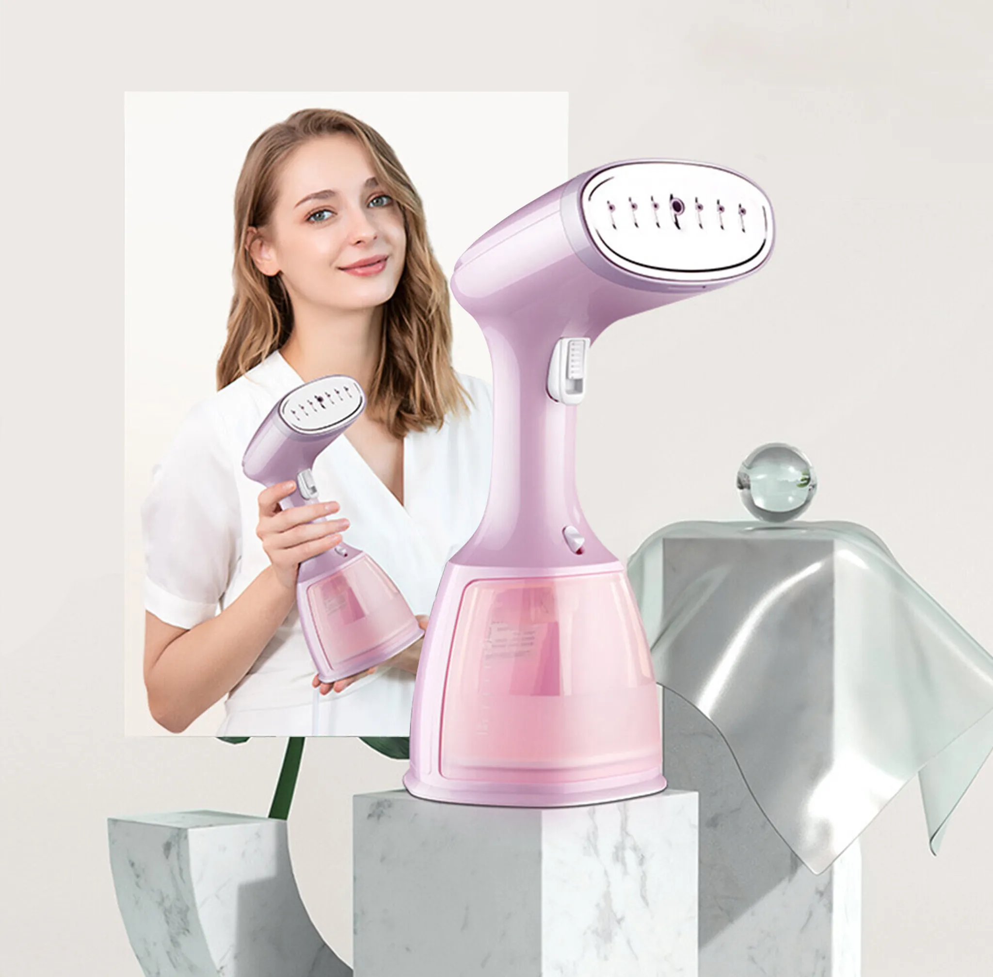 Eine Frau hält einen kleinen Dampfgarer, neben ihr steht ein größerer Dampfgarer. Beide sind rosa. Weißer Hintergrund.