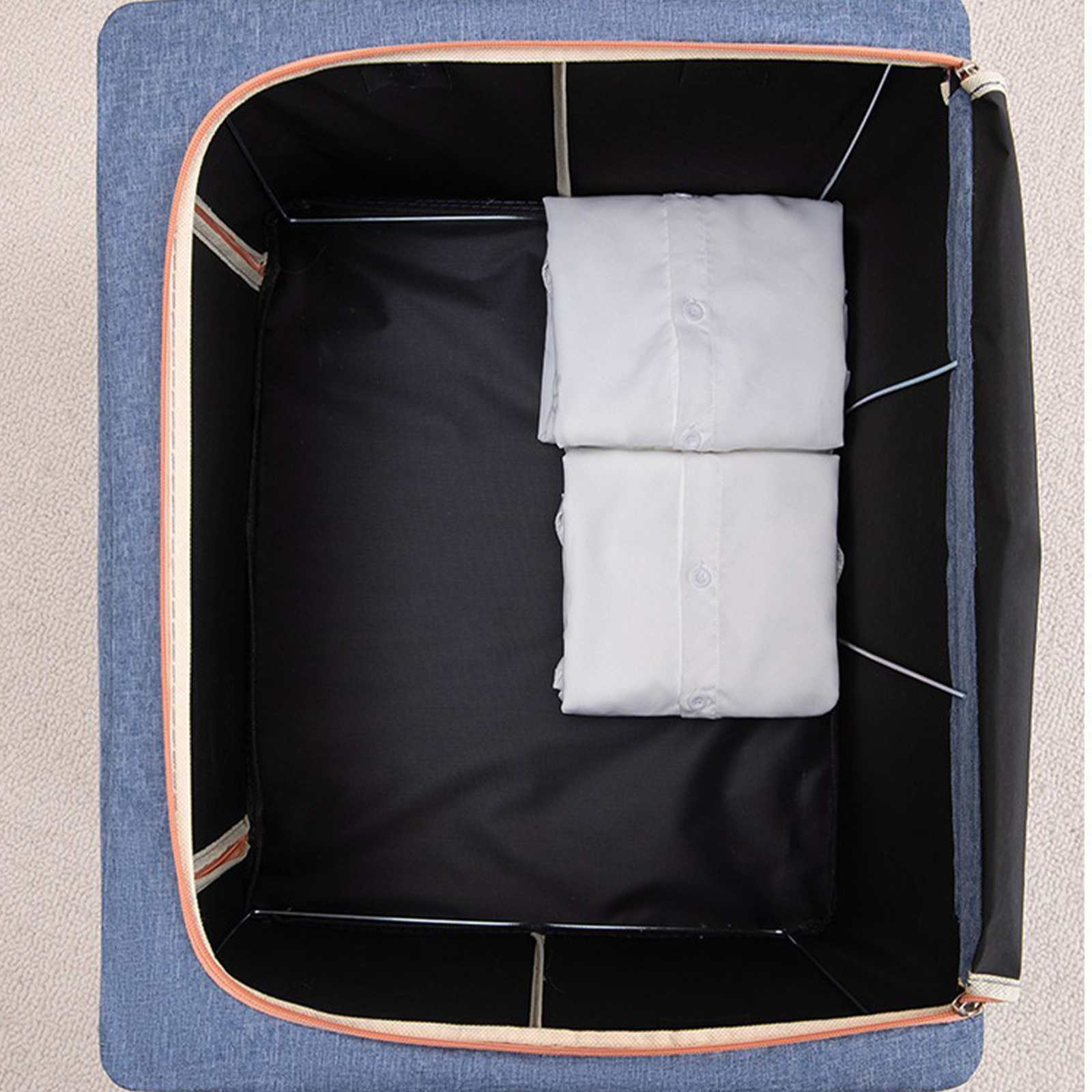 Offene Aufbewahrungsbox mit zwei gefalteten weißen Hemden. Die Box ist blau mit schwarzem Innenraum.