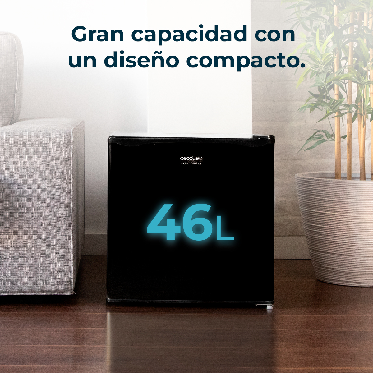 Un mini-frigorifero nero con '46L' in blu. Accanto, un divano e una pianta in vaso.