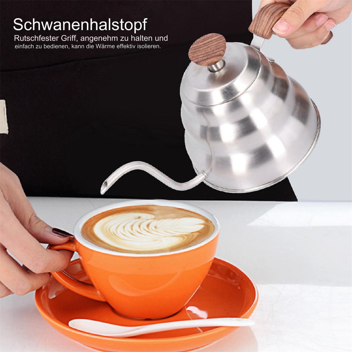 Eine Hand gießt aus einem silbernen Schwanenhalskessel in eine orangefarbene Kaffeetasse mit Latte Art auf einer orangefarbenen Untertasse mit einem weißen Löffel.