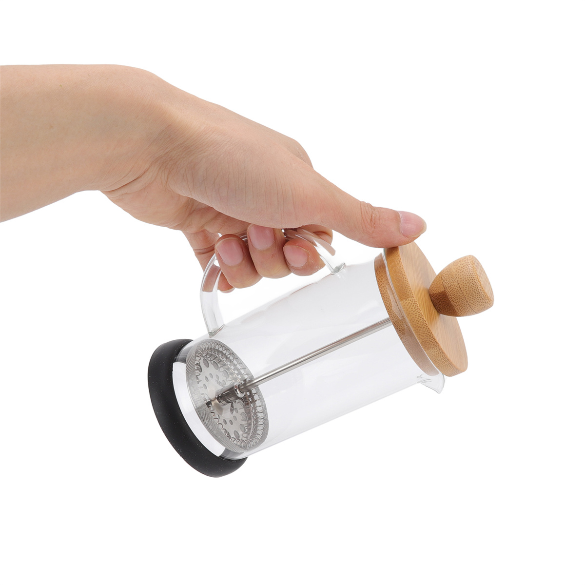 Eine Hand hält eine French Press aus Glas mit einem Holzdeckel und -griff. Der Hintergrund ist weiß.