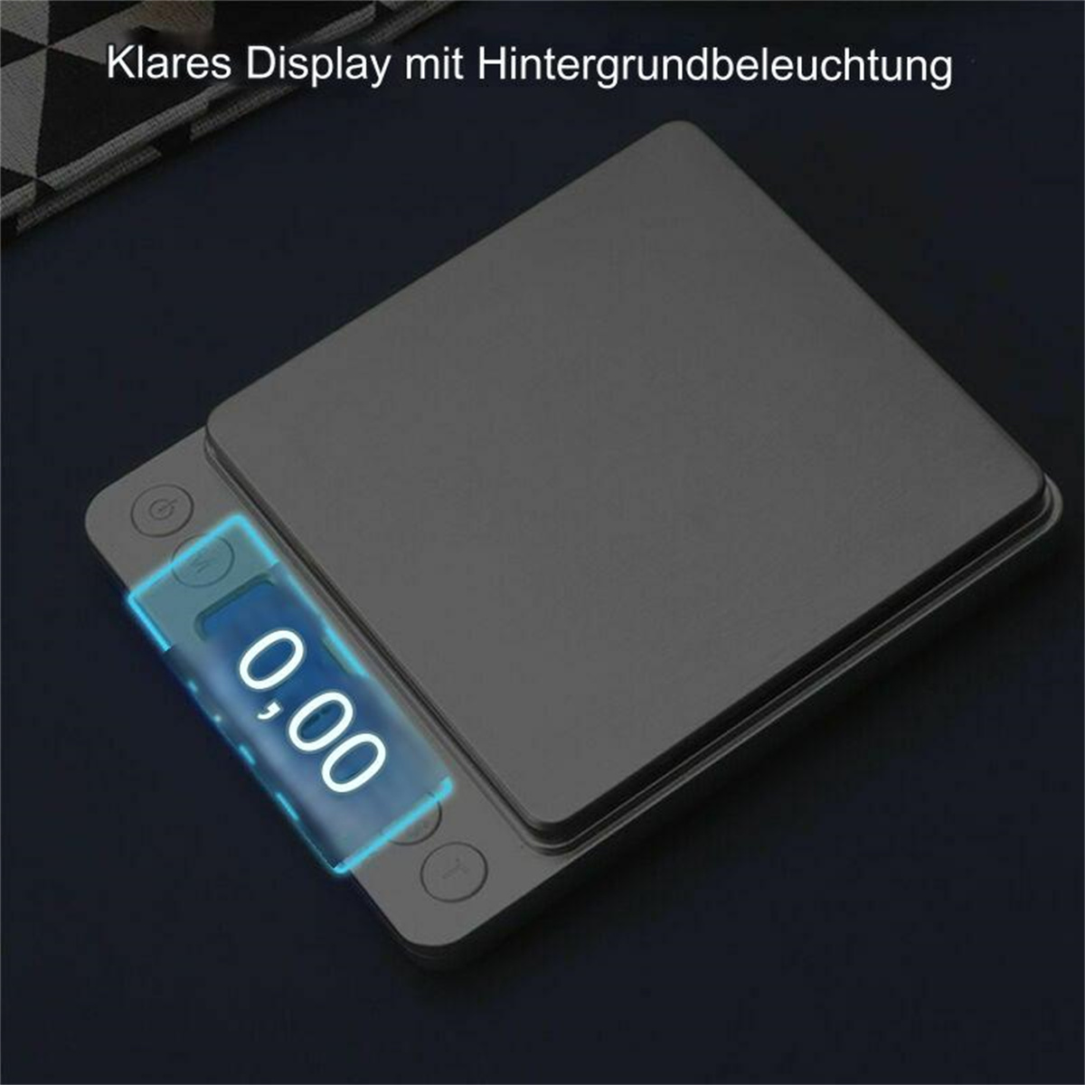 Eine graue Digitalwaage mit der Anzeige '0,00'. Das Display ist blau beleuchtet. Die Waage befindet sich auf einer dunklen Oberfläche.