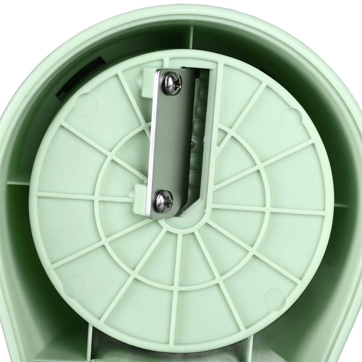 Nahaufnahme eines grünen Gemüsespiralizers aus Kunststoff. Eine silberne Klinge ist sichtbar. Der Spiralschneider hat ein kreisförmiges Design.