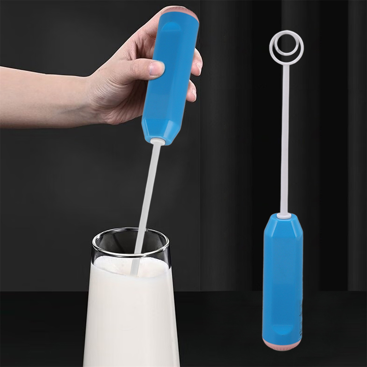 Eine Hand hält einen blauen Milchaufschäumer, der Milch in einem Glas verrührt. Ein weiterer Aufschäumer steht aufrecht. Dunkler Hintergrund.