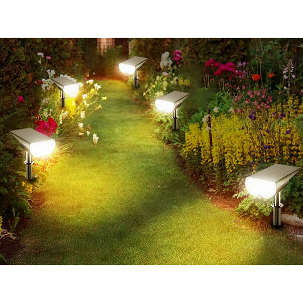 Gartenweg beleuchtet von Solarleuchten. Blumen und Grün säumen den Weg und schaffen eine warme, einladende Atmosphäre in der Dämmerung.