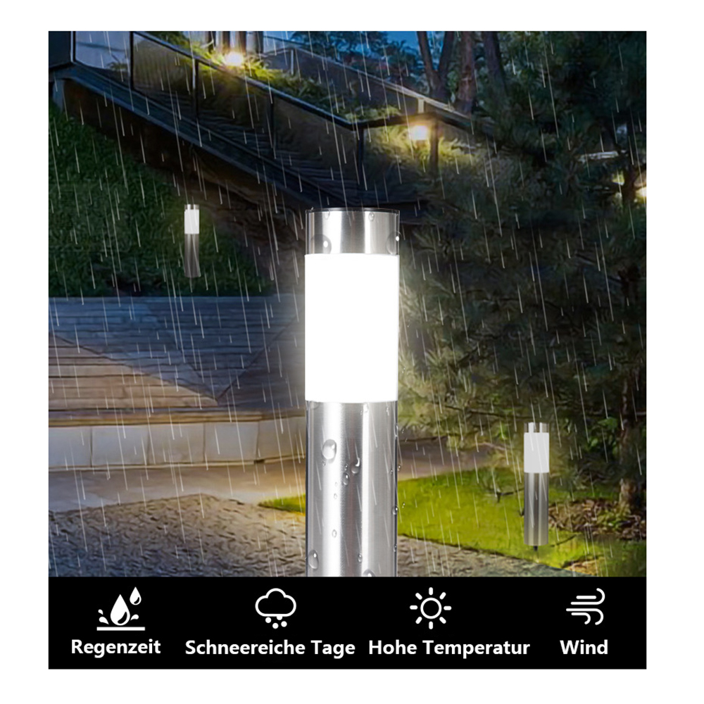 Regnerische Szene mit beleuchteten Edelstahl-Lampen. Regentropfen fallen. Grüne Büsche und eine Treppe im Hintergrund. Weißes Licht.