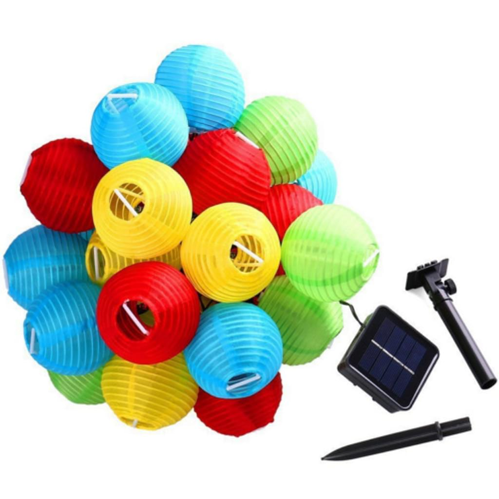 Bunte Papierlaternen in Rot, Gelb, Blau und Grün. Solarpanel und Montageausrüstung im Hintergrund.