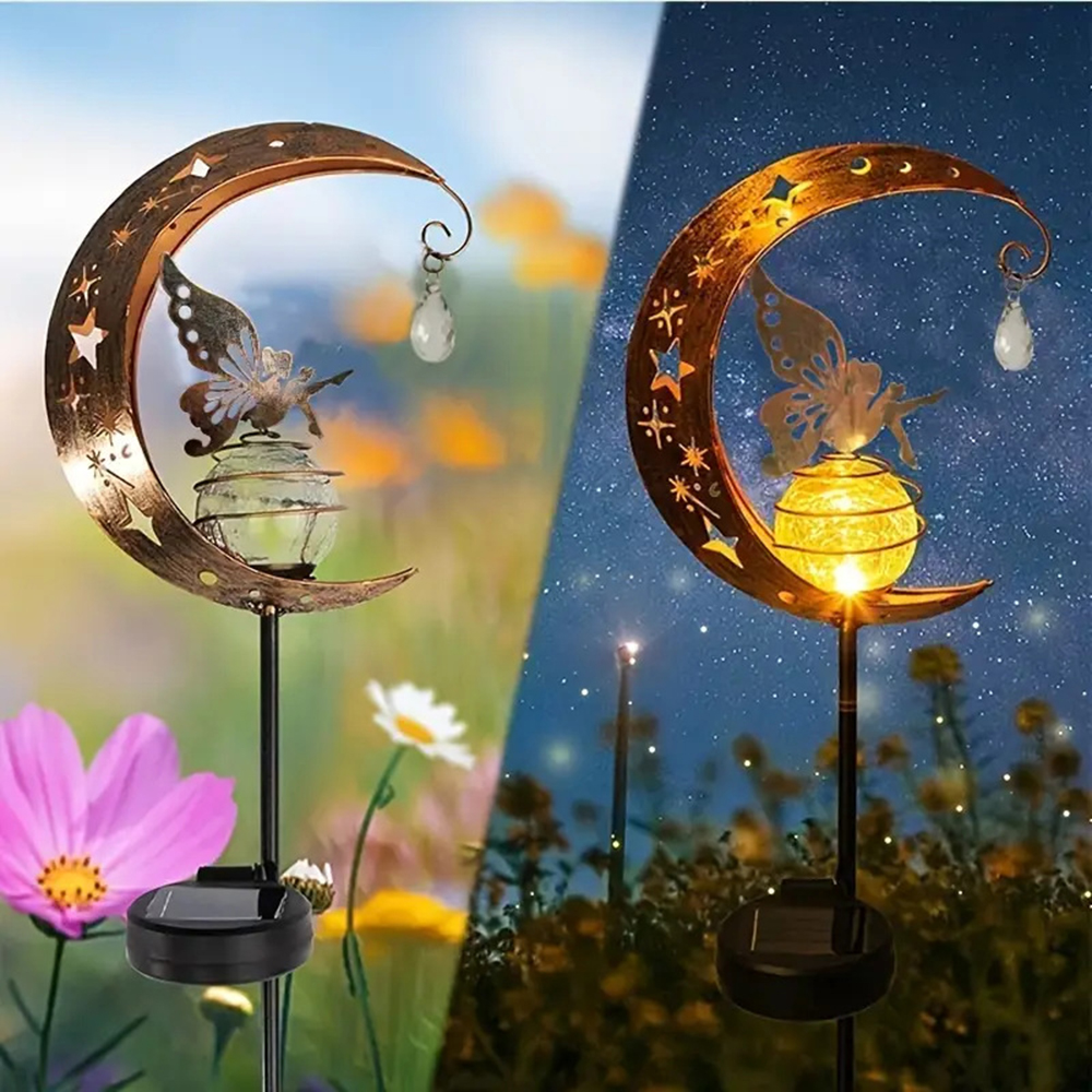 Zwei Gartenleuchten mit Mond- und Schmetterlingsdesign. Eine ist bei Tageslicht, die andere nachts. Blumen sind im Hintergrund.