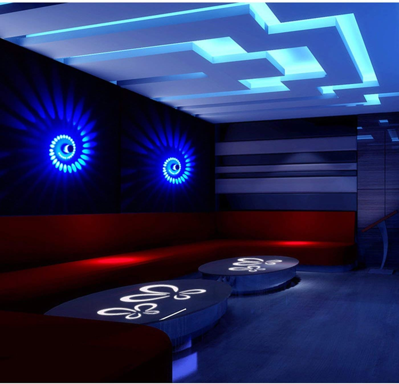 Ein Nachtclub-Interieur mit blauer und roter Beleuchtung. Spiralformige Lichter an schwarzen Wänden, rote Sitzgelegenheiten und ovale Tische.