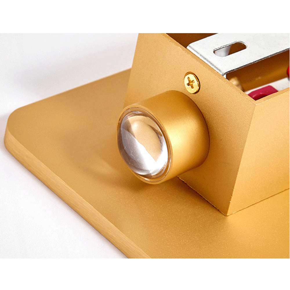 Eine goldene Lampe mit klarer Linse, Schraube und rechteckiger Struktur. Der Hintergrund ist weiß.