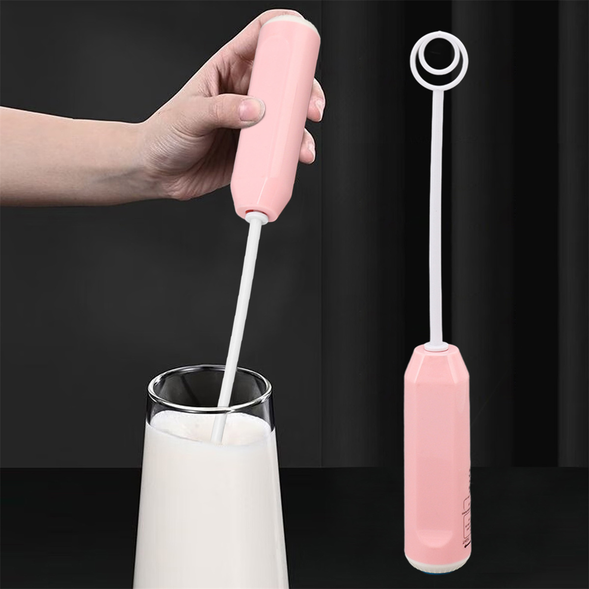Eine Hand hält einen rosa Milchaufschäumer über einem Glas Milch. Ein weiterer Aufschäumer ruht rechts. Dunkler Hintergrund.