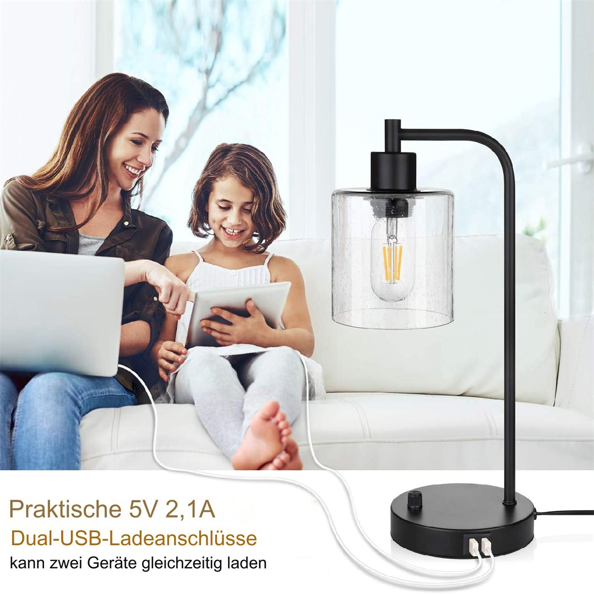 Eine Frau und ein Mädchen sitzen mit Laptop und Tablet auf einer Couch. Eine schwarze Lampe mit USB-Ladeanschlüssen steht daneben.