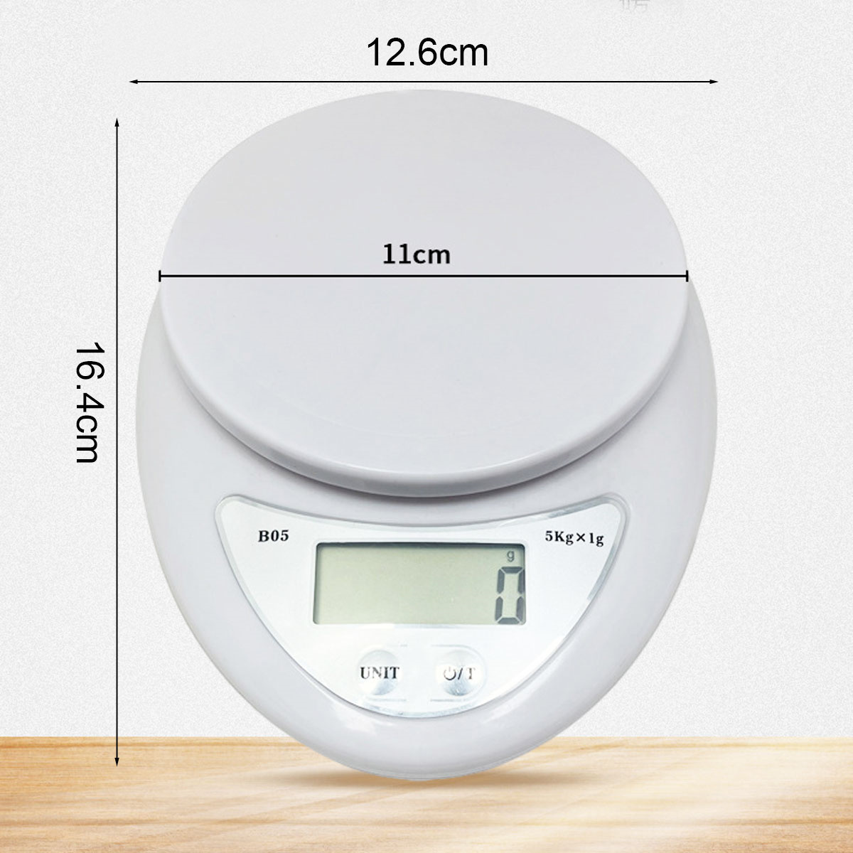 Weiße digitale Küchenwaage mit Abmessungen. Die Waage zeigt 0 g an. Text lautet B05, 5 kg x 1 g, UNIT und Ein/Aus. Hintergrund ist hell.