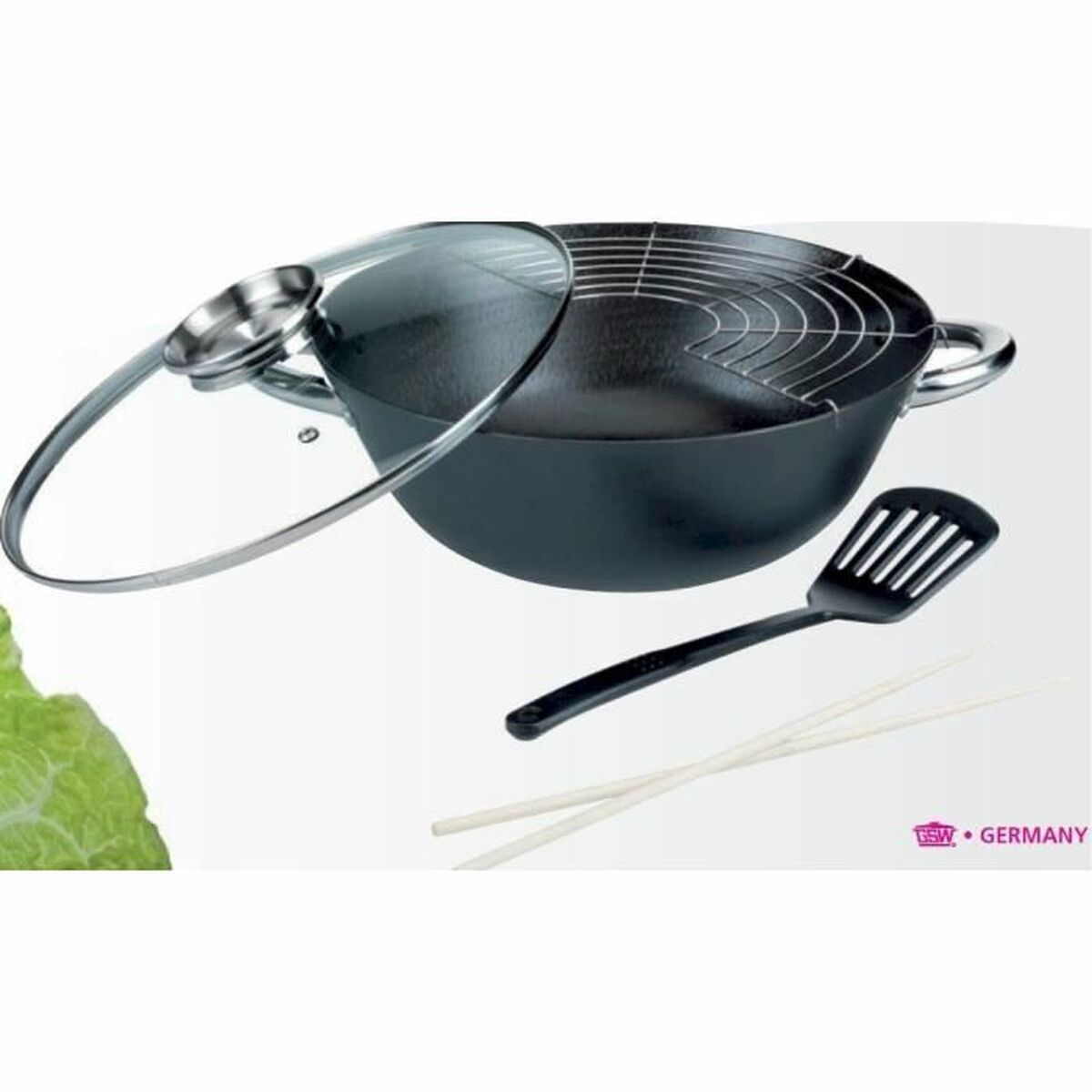 Ein schwarzer Wok mit Glasdeckel, Spatel und Essstäbchen. Ein Metallrost befindet sich im Wok. Der Hintergrund ist weiß.