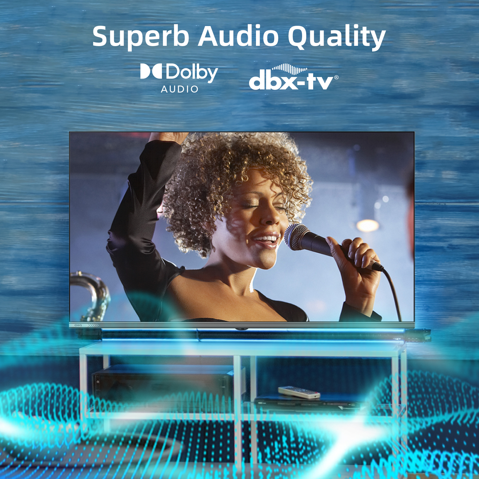 Kobieta śpiewa do mikrofonu w telewizji. Telewizor stoi na białym stojaku. Niebieskie fale na pierwszym planie.