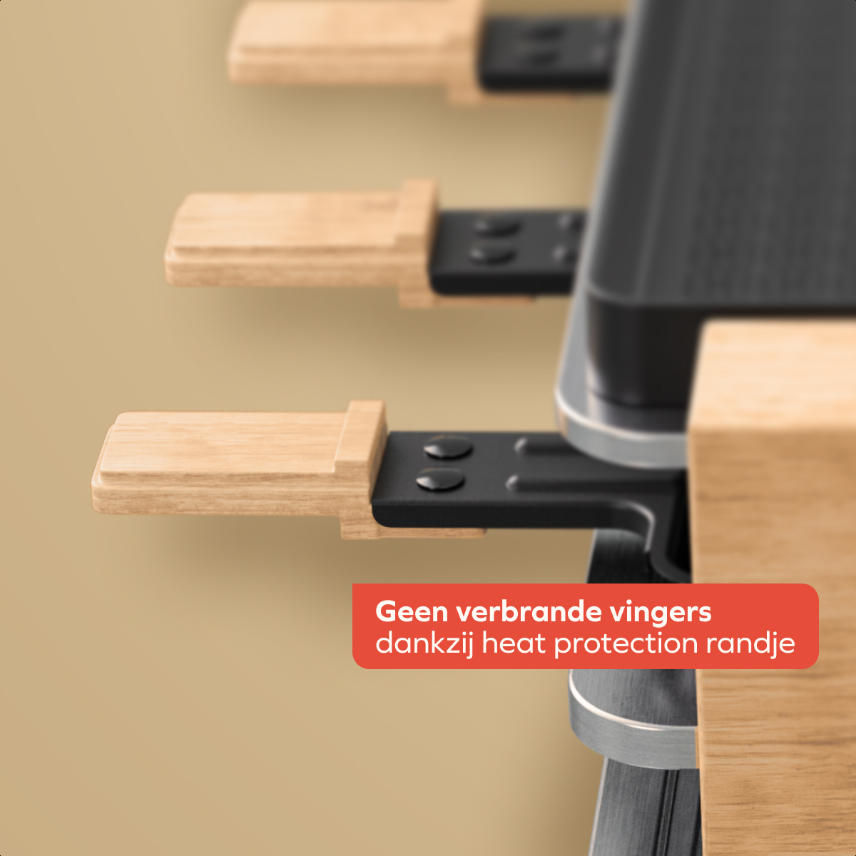 Close-up of a kitchen appliance with wooden handles and a black surface. A text bubble says 'No burnt fingers thanks to heat protection'.