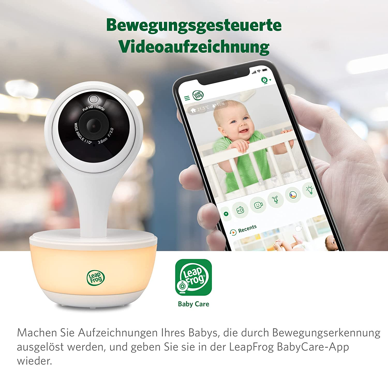 Ein Babyphone mit Kamera und Smartphone, das ein Baby in einem Kinderbett zeigt. Die Kamera ist weiß, das Telefon wird von einer Hand gehalten.