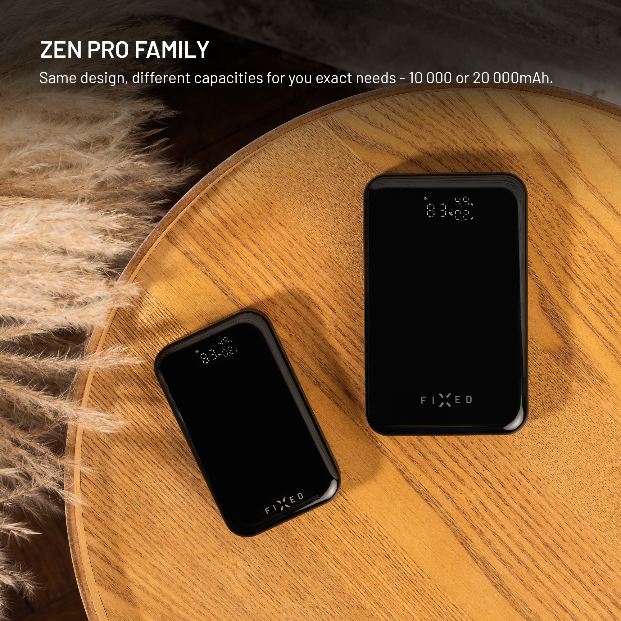 Zwei schwarze Powerbanks auf Holzoberfläche, eine kleiner, eine größer. Beide haben Displays mit Zahlen und der Marke FIXED.