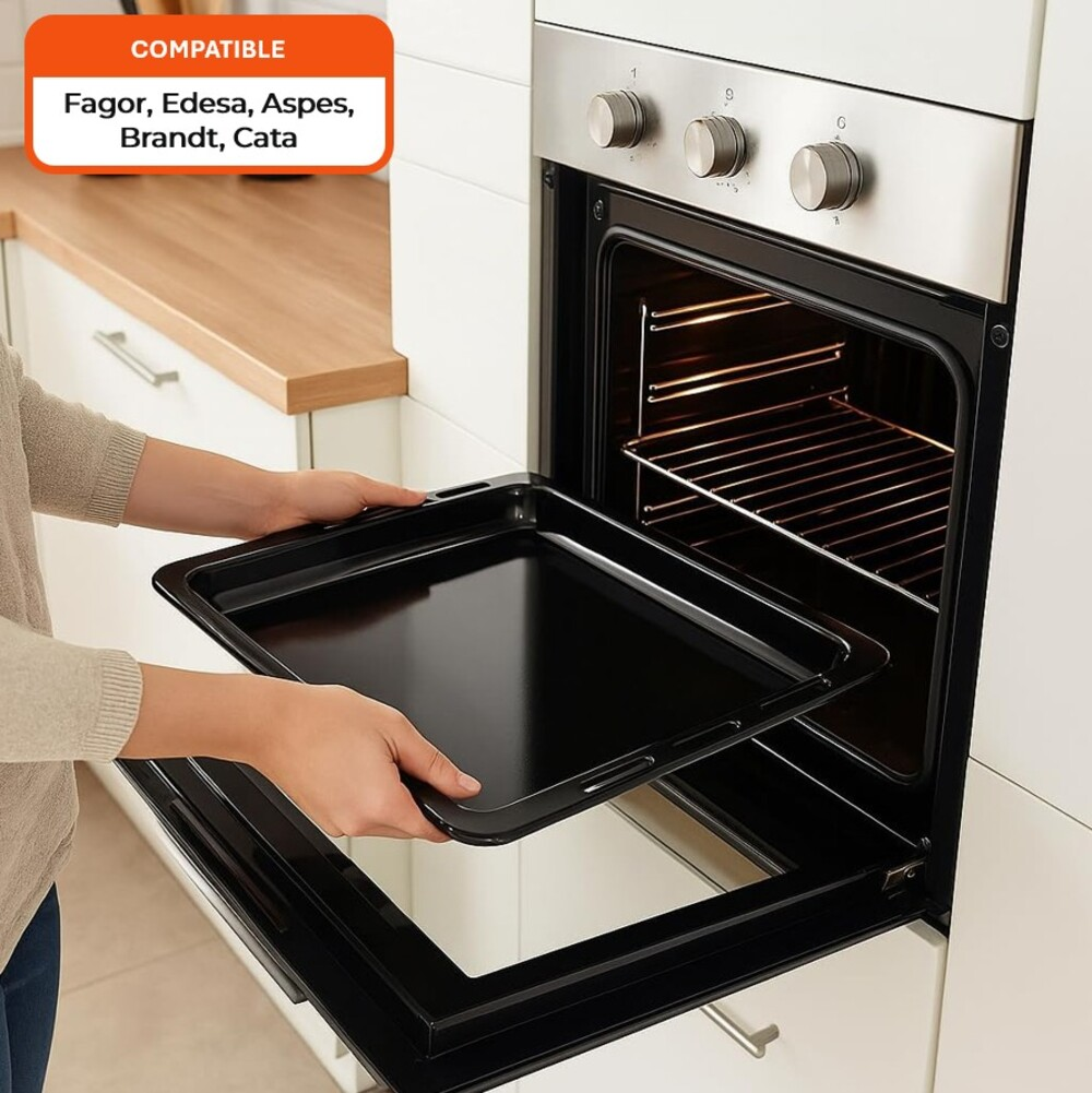 Una persona coloca una bandeja negra para hornear en un horno abierto. El horno es de acero inoxidable. El texto sobre el horno dice marcas compatibles.