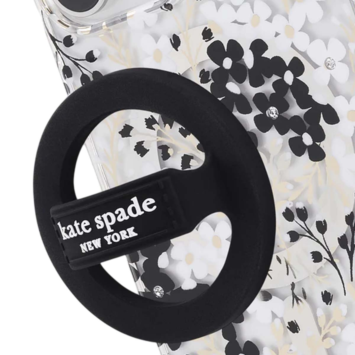 Un supporto per telefono nero con 'kate spade NEW YORK' è attaccato a una custodia con un motivo floreale.