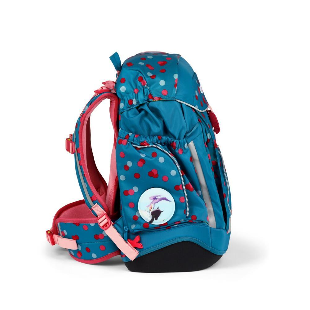 Ein blauer Rucksack mit roten Tupfen und rosa Akzenten. Er hat eine Seitentasche und einen runden Aufnäher mit einem Cartoon-Bild.