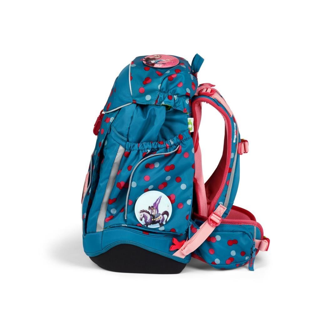 Ein türkisfarbener Rucksack mit roten und weißen Tupfen. Er hat rosa Träger und ein Cartoon-Bild. Der Boden ist schwarz.